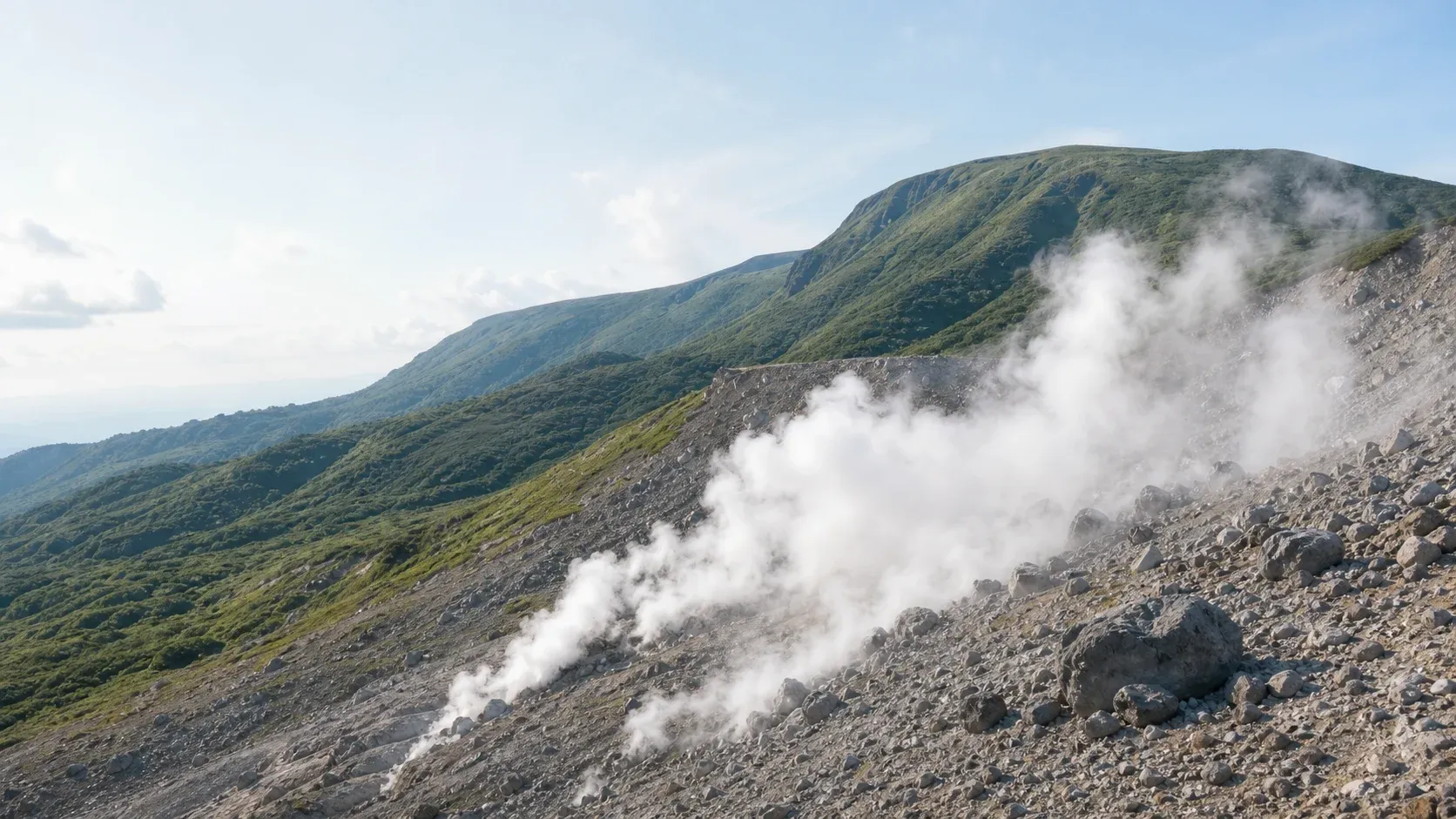 八幡平市の山並みと地熱資源を象徴する蒸気の上がる風景